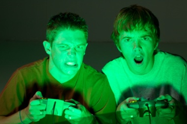 Two young men sitting playing video games